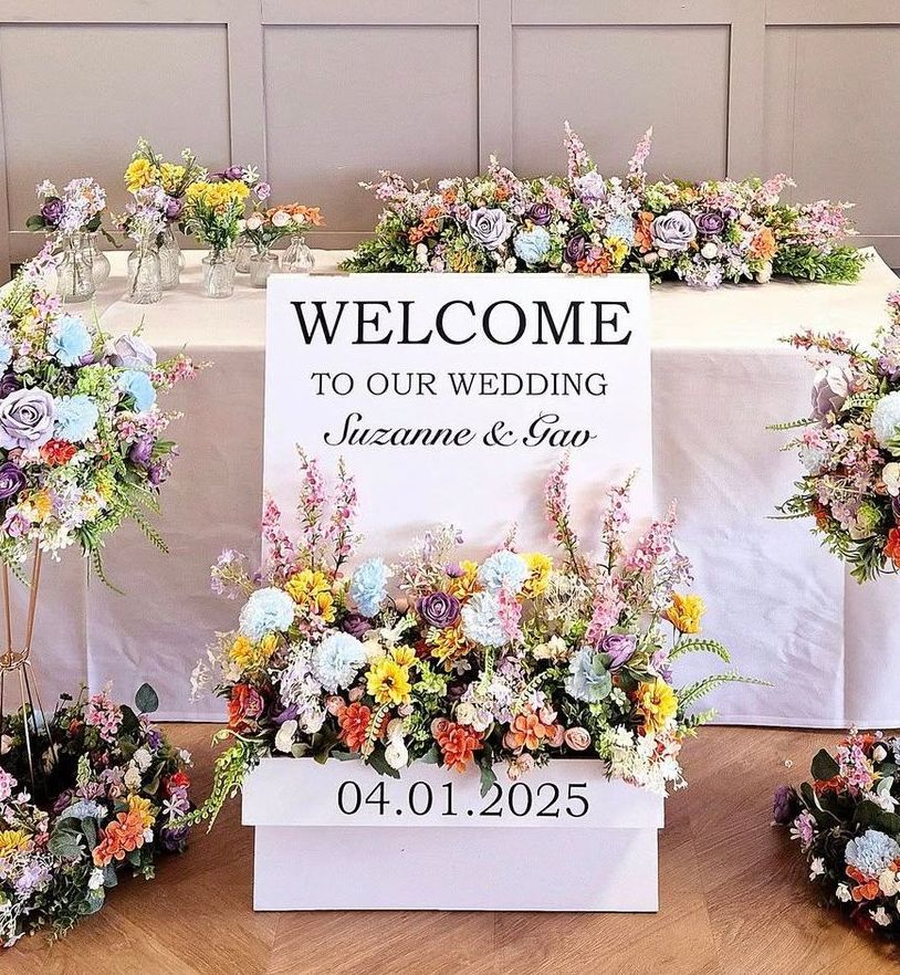 Vibrant mixed flower colour centrepiece on gold stand.
