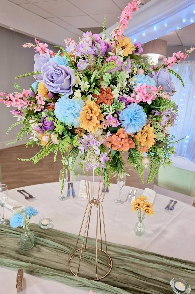 Burnt orange and green foliage moongate arch with ceremony table garland.