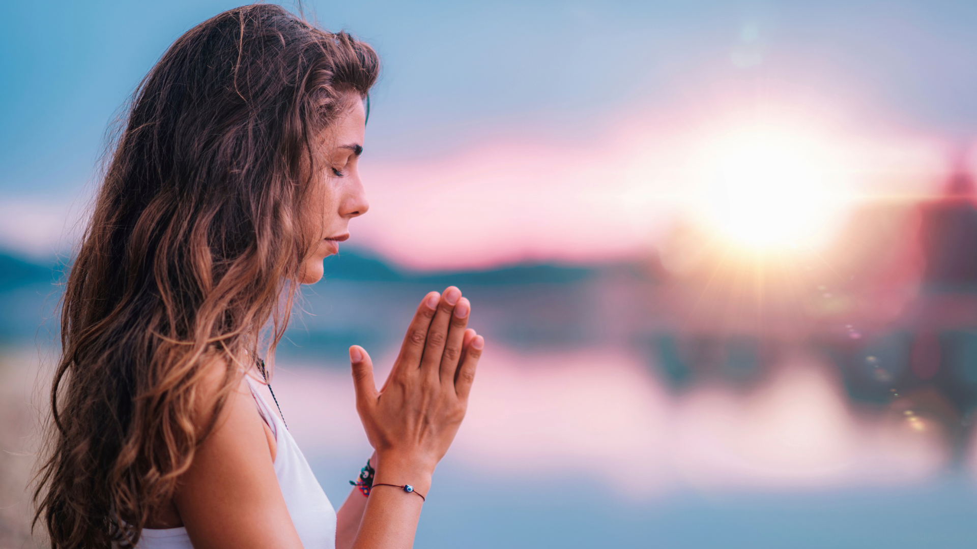 Frau Meditiert mit Sonnenuntergang im Hintergrund