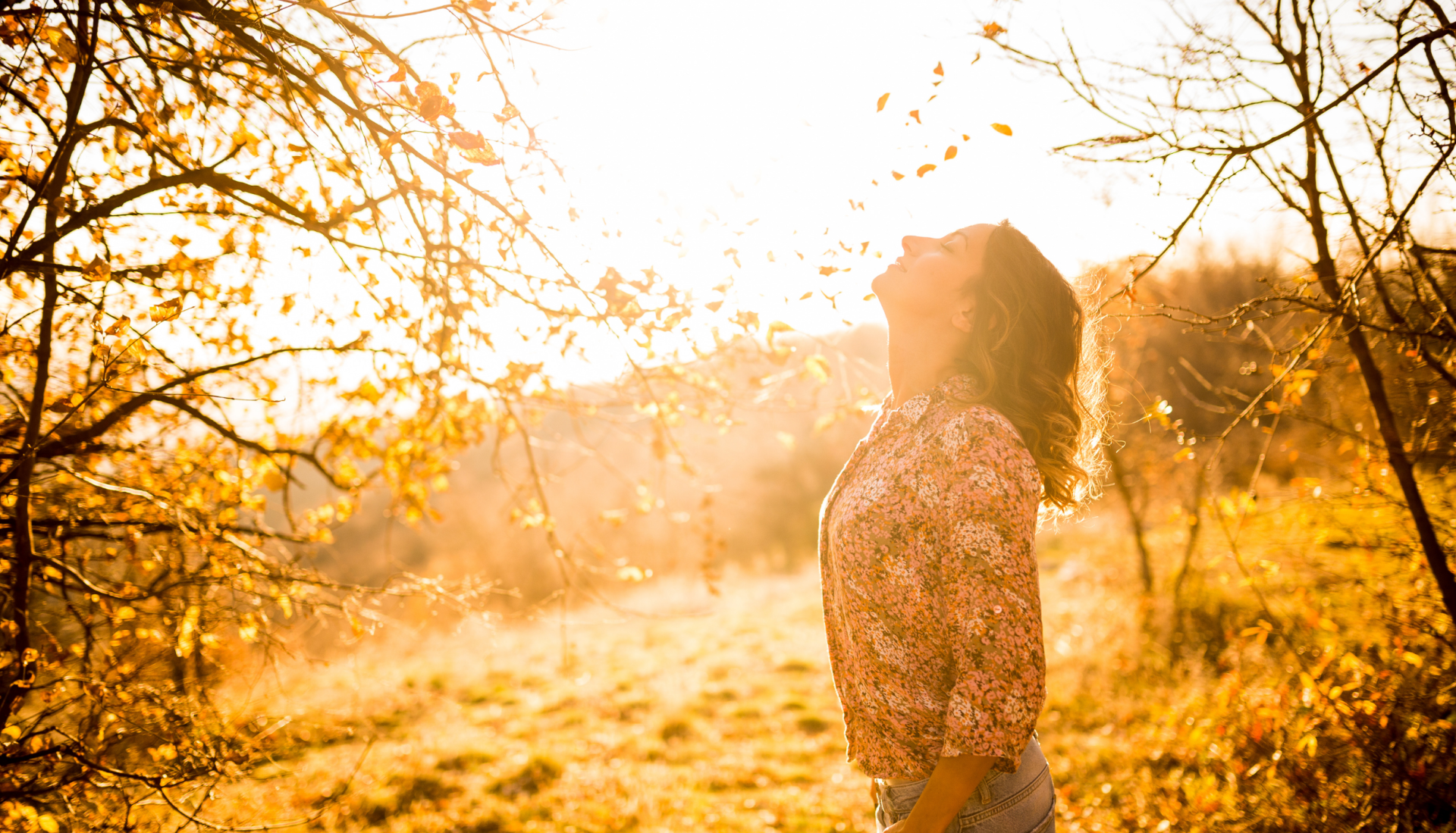 Frau in herbstlicher Natur mit geschlossenen Augen – Symbolbild für Ruhe und Erleichterung nach EMDR in Hamburg
