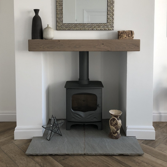 Charnwood log burning stove with a decorative beam, fireboarded chamber and Indian stone hearth