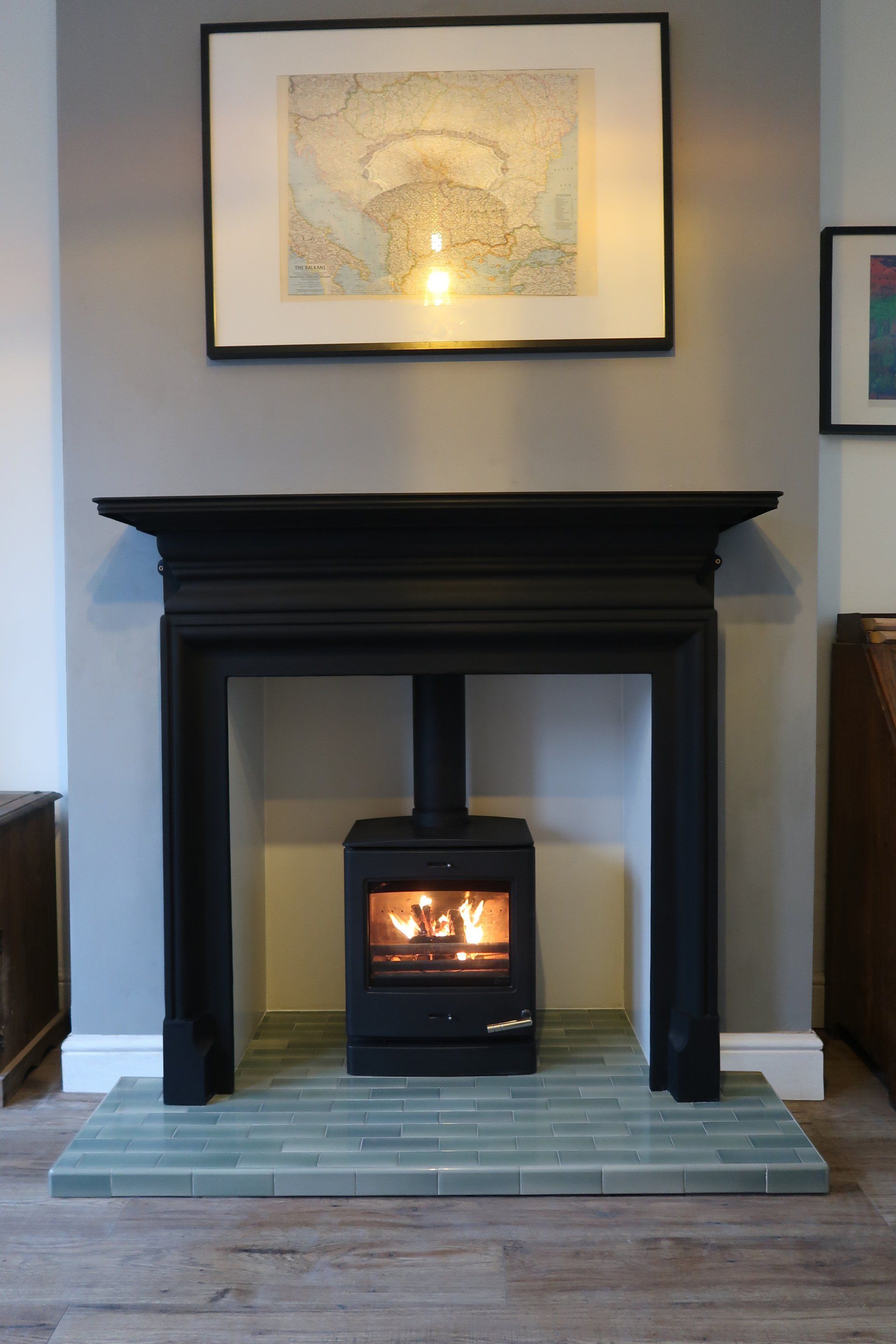 Cast iron fireplace surround with a quarry tiled hearth and eco ready defra wood burning stove