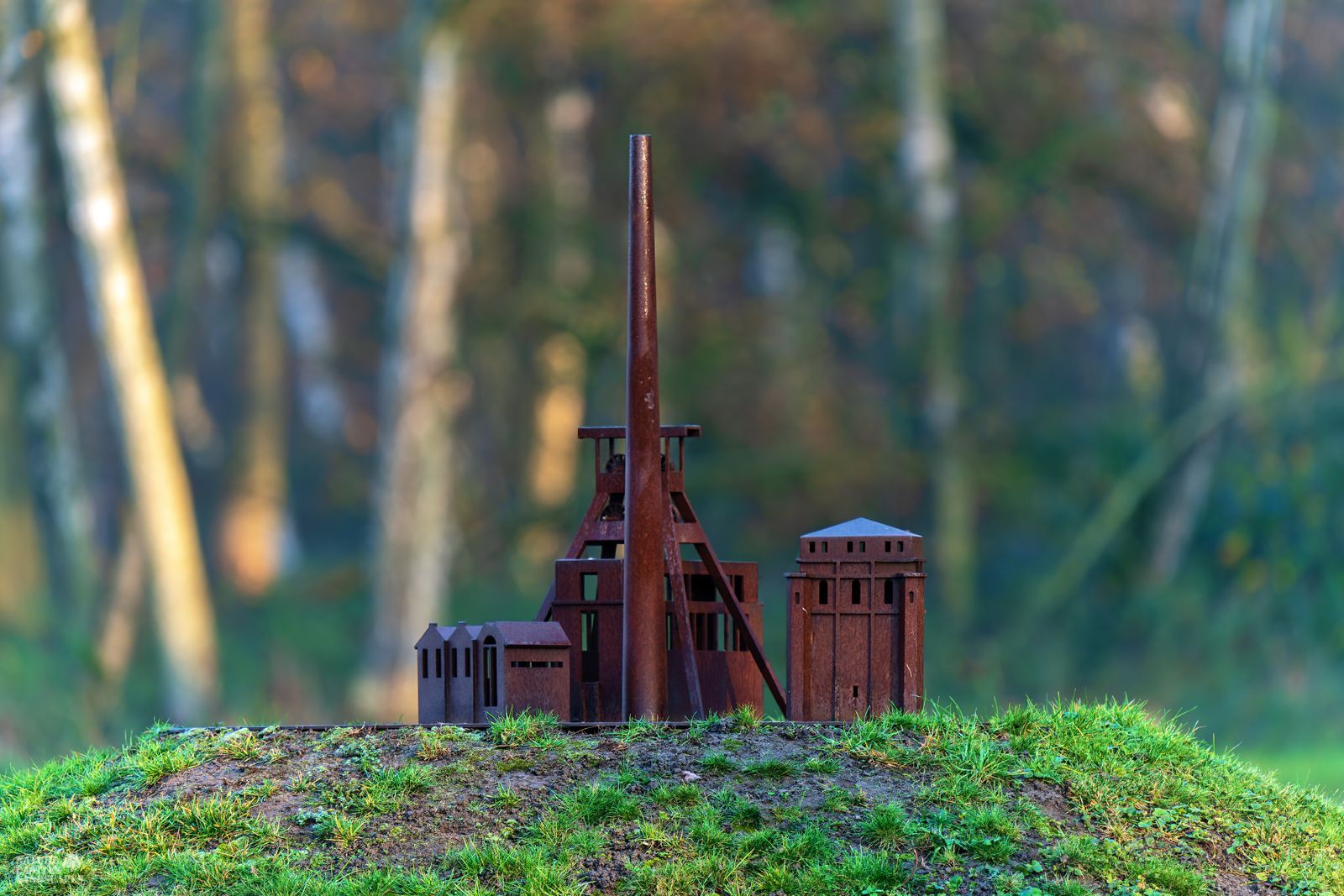rusty metal model of a colliery on a hill