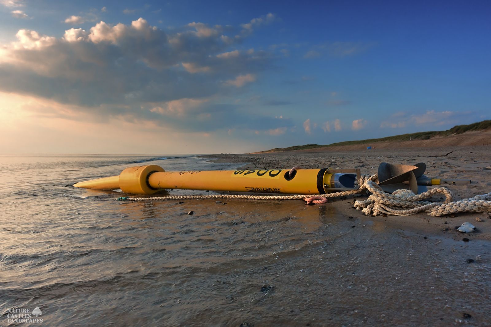 jetsam and flotsam on the Danish North Sea coast after the storm a buoy lays on the beach