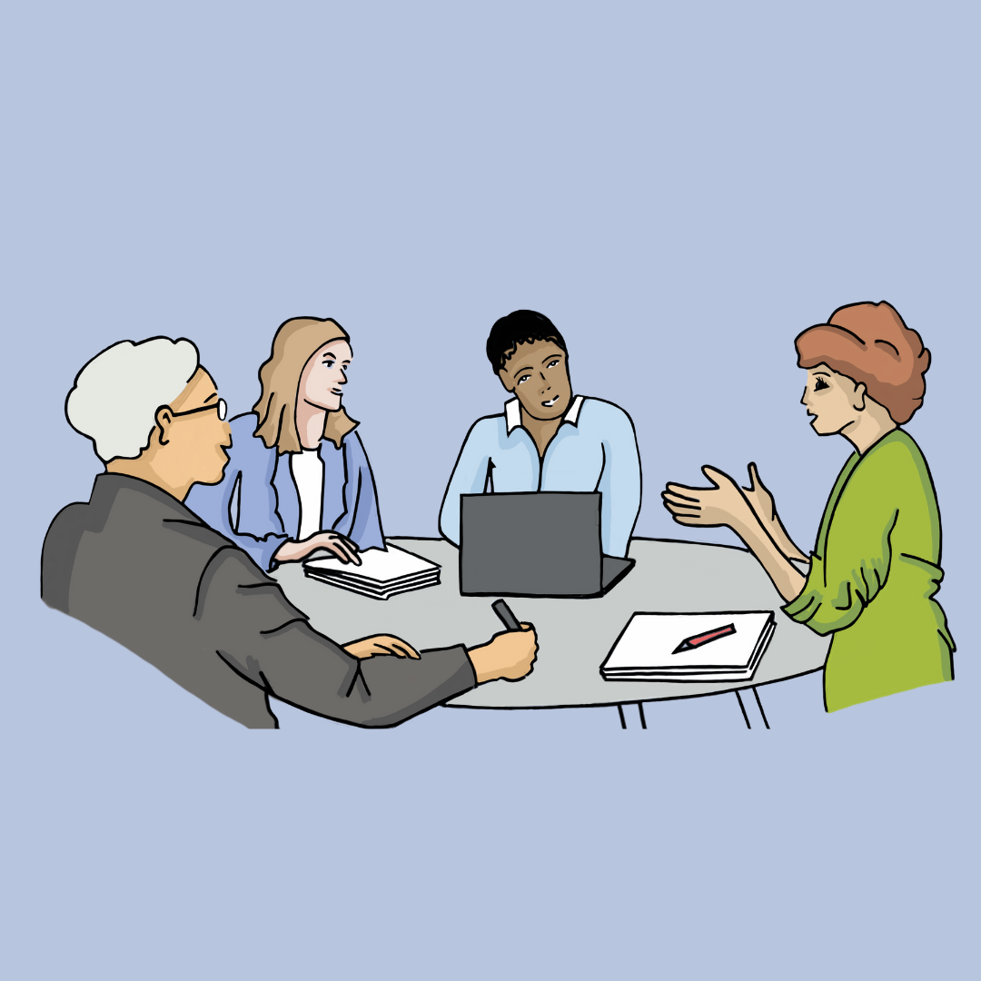 Vier Personen sitzen an einem runden Tisch und sprechen miteinander. Zwei Männer und zwei Frauen unterschiedlichen Alters hören sich zu. Vor ihnen liegen ein Laptop, Notizblätter und Stifte. Alle Personen tragen Alltagskleidung.