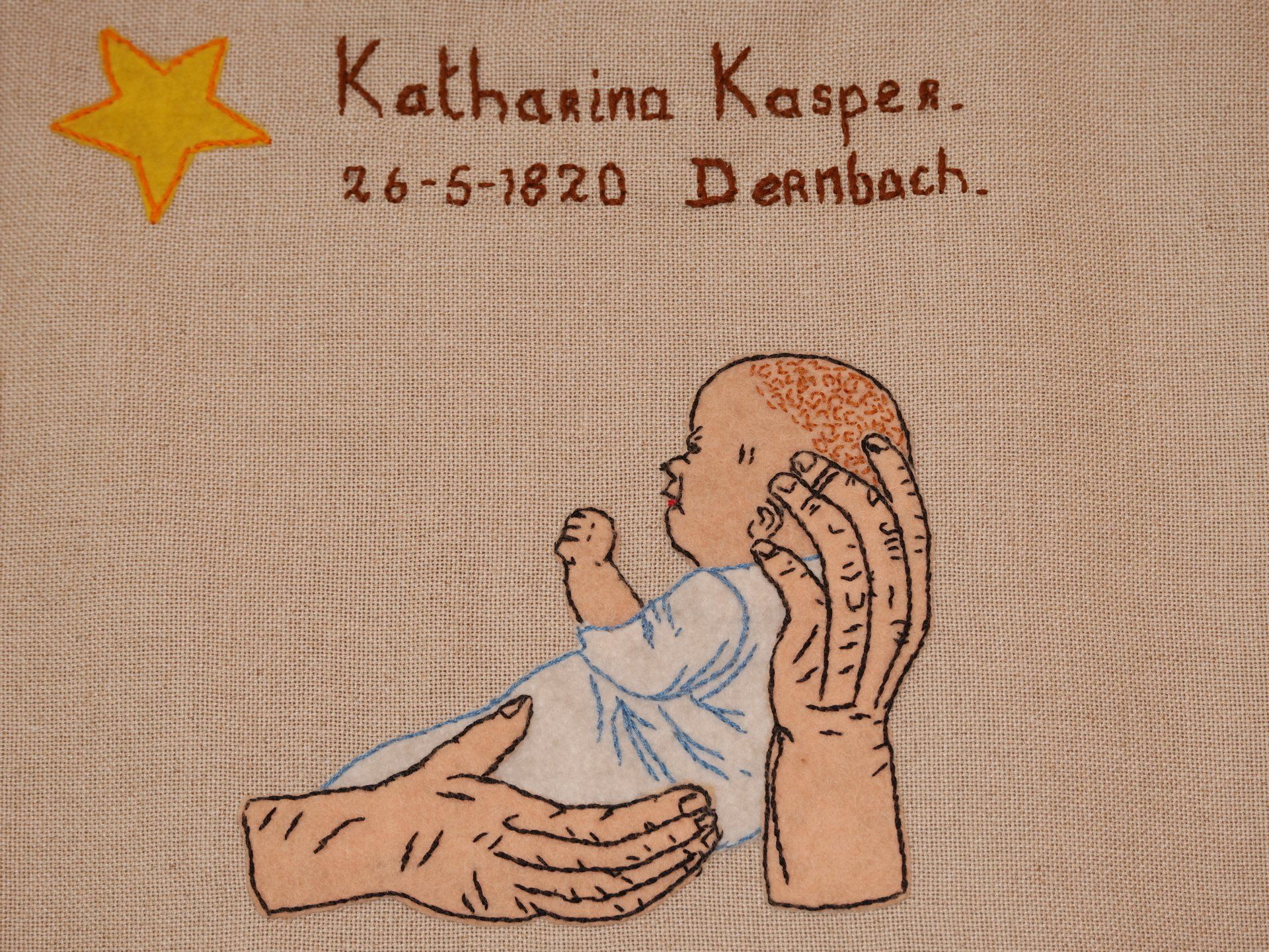 gesticktes Bild von Katharina als Baby mit ihrem Geburtstag 26.5.1820 in Dernbach