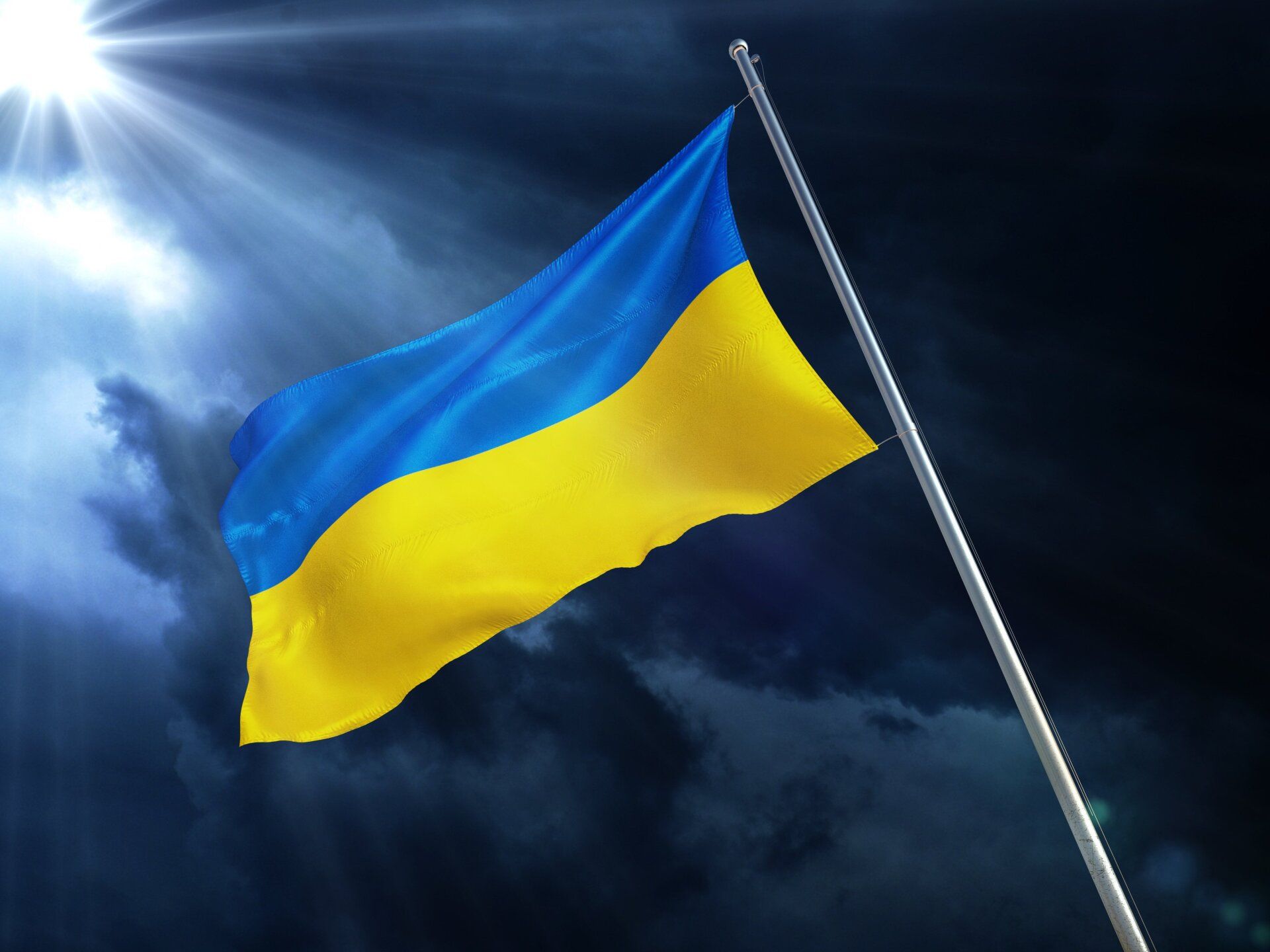 Ukrainische Flagge vor dunklem Himmel