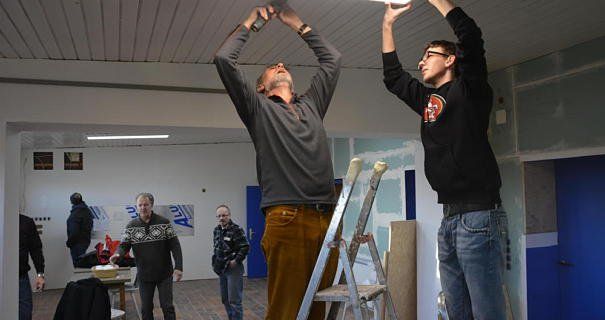 Peter Matheisel und Marcel Hoffmann bringen eine Deckenleuchte an. Auch im Hintergrund wird fleißig gewerkelt Peter Matheisel und Marcel Hoffmann bringen eine Deckenleuchte an. Auch im Hintergrund wird fleißig gewerkelt