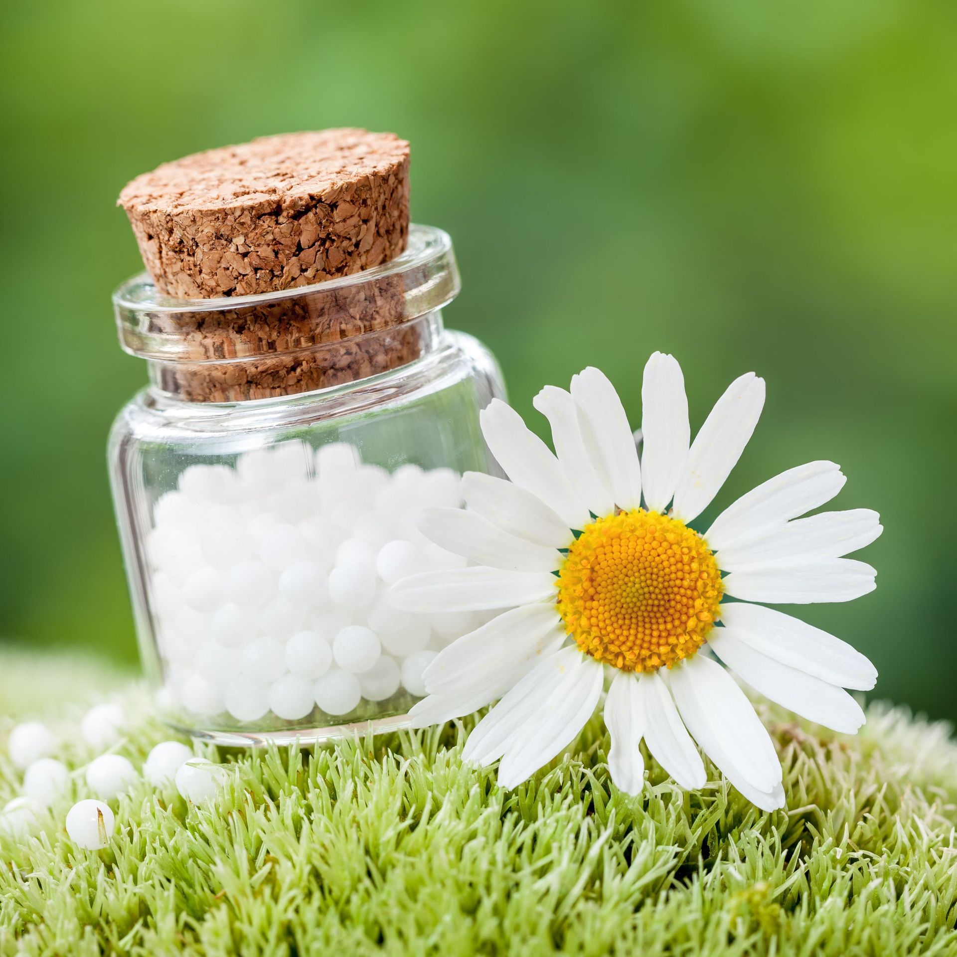 Homöopathie in Glasflasche mit Kamillenblüte