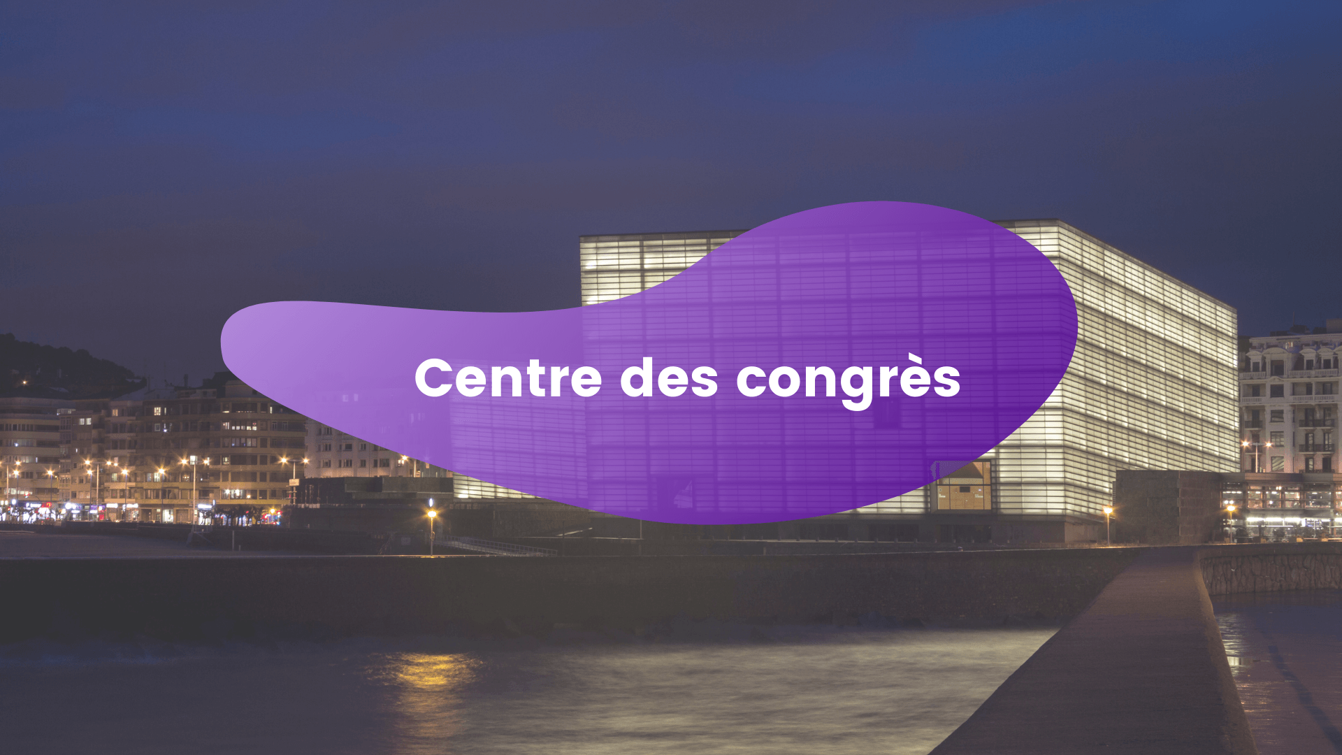 Image du centre des congrès de nuit avec une bulle violette en avant où il y a écrit 