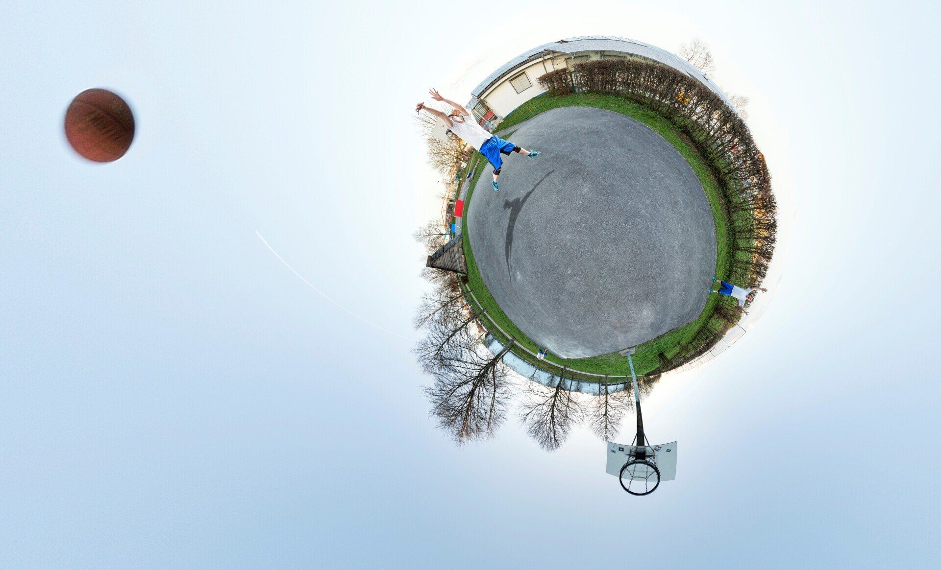 Mark Bruskowski von SEO-Lektorat Einwandfrei wirft einen Basketball, mit Kunst als Kugelpanorama fotografiert auf dem Basketballplatz in Steinmauern