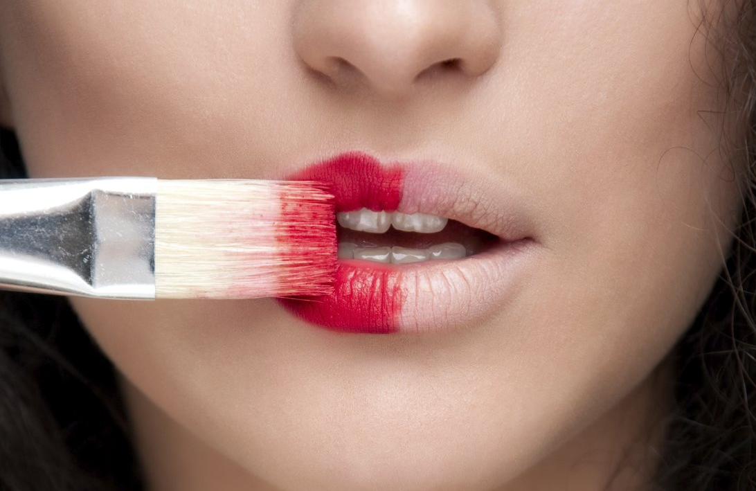 Lips being brushed with red lisptick