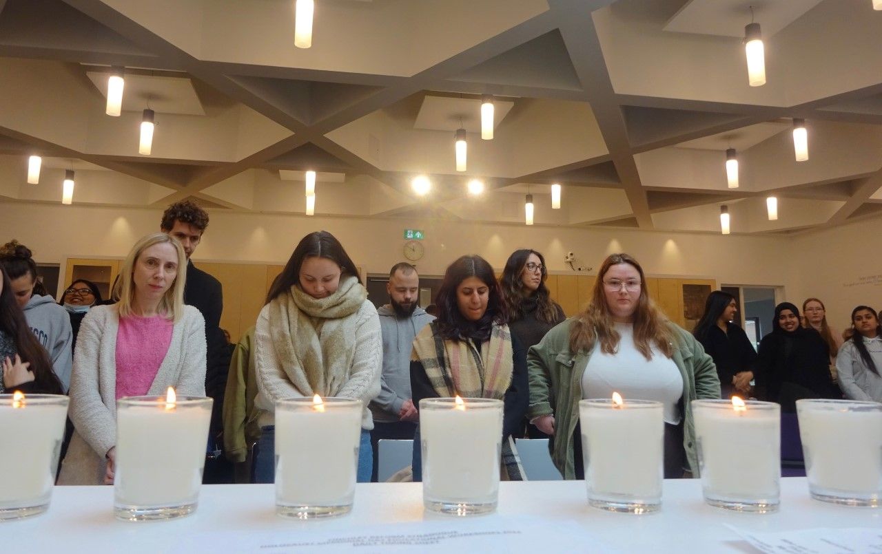 Students with candles in foregroiund
