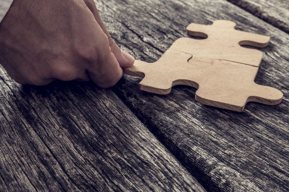 A person puts a piece in a jigsaw puzzle