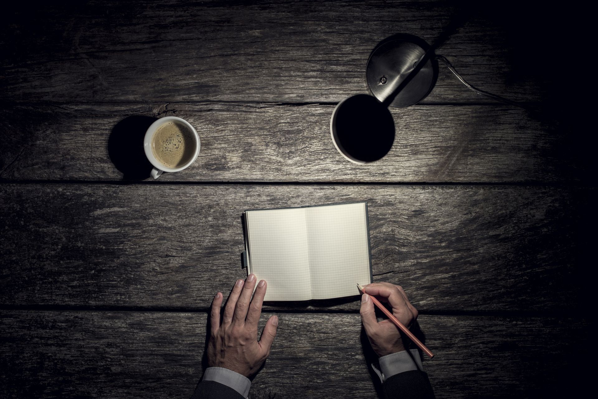 A person makes notes in a notebook