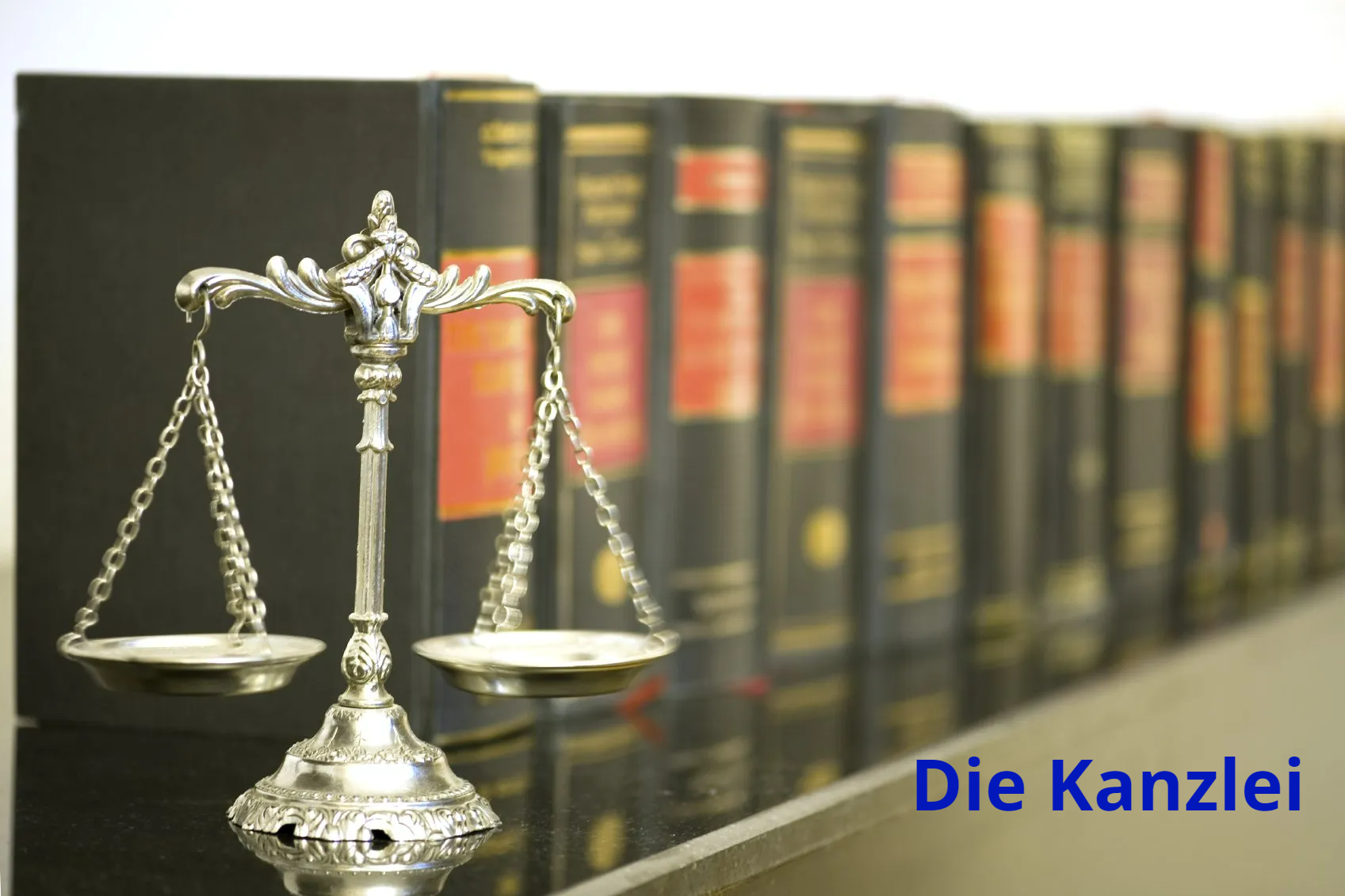 Das Bild zeigt eine Waage sowie eine Reihe von Büchern und juristischen Kommentaren.