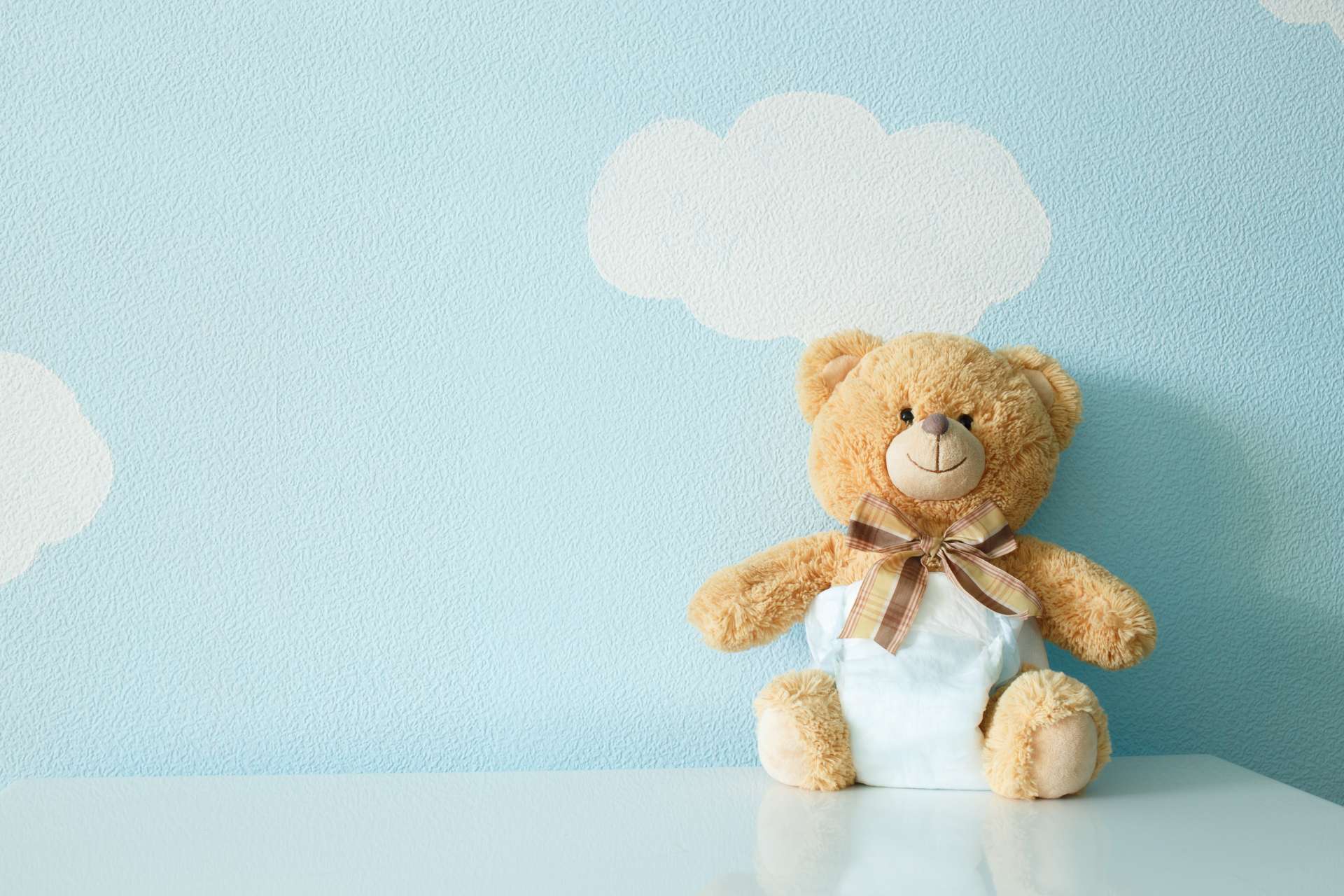 Teddybär vor blauer Wand