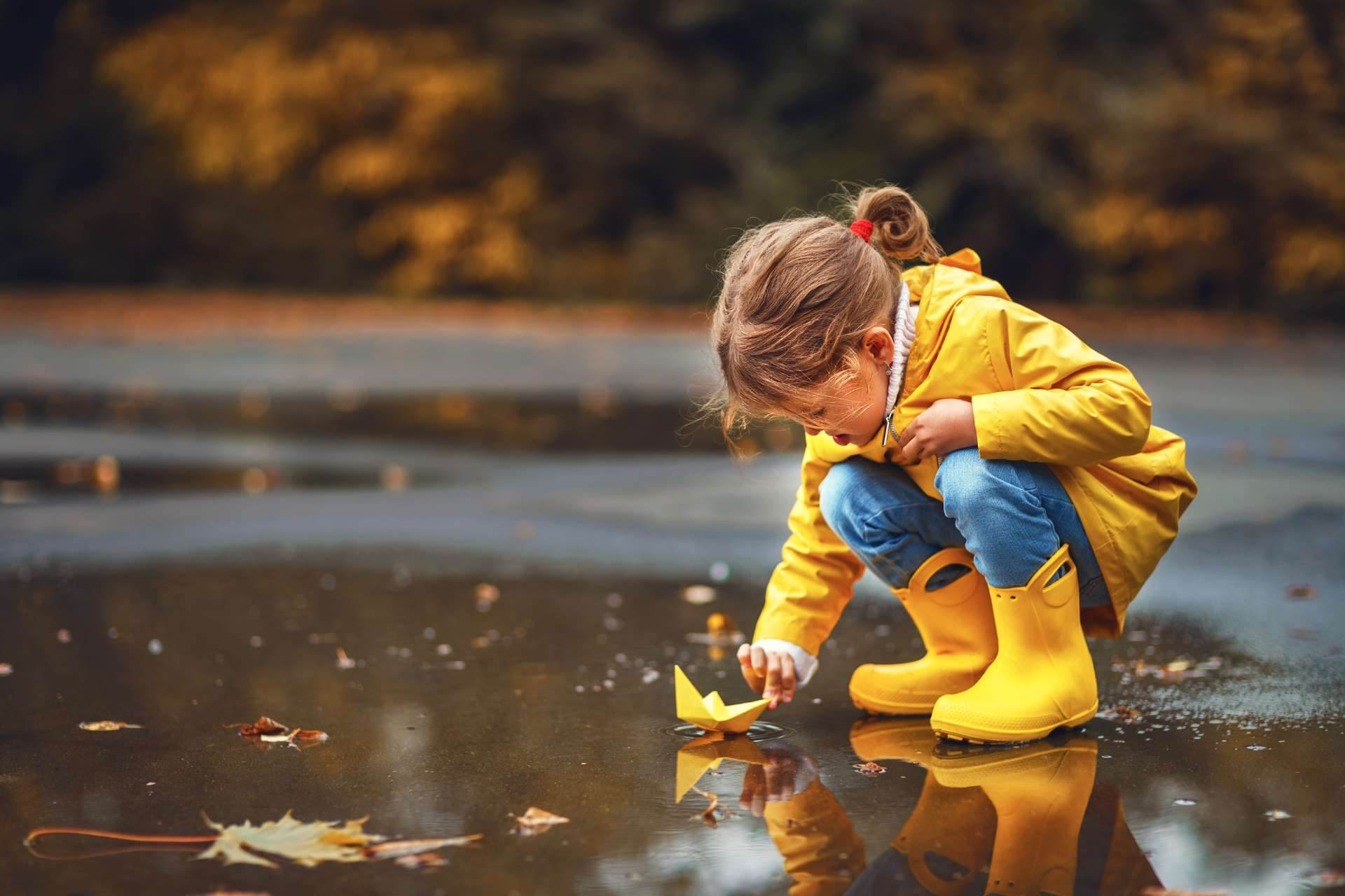 Kind spielt im Regen