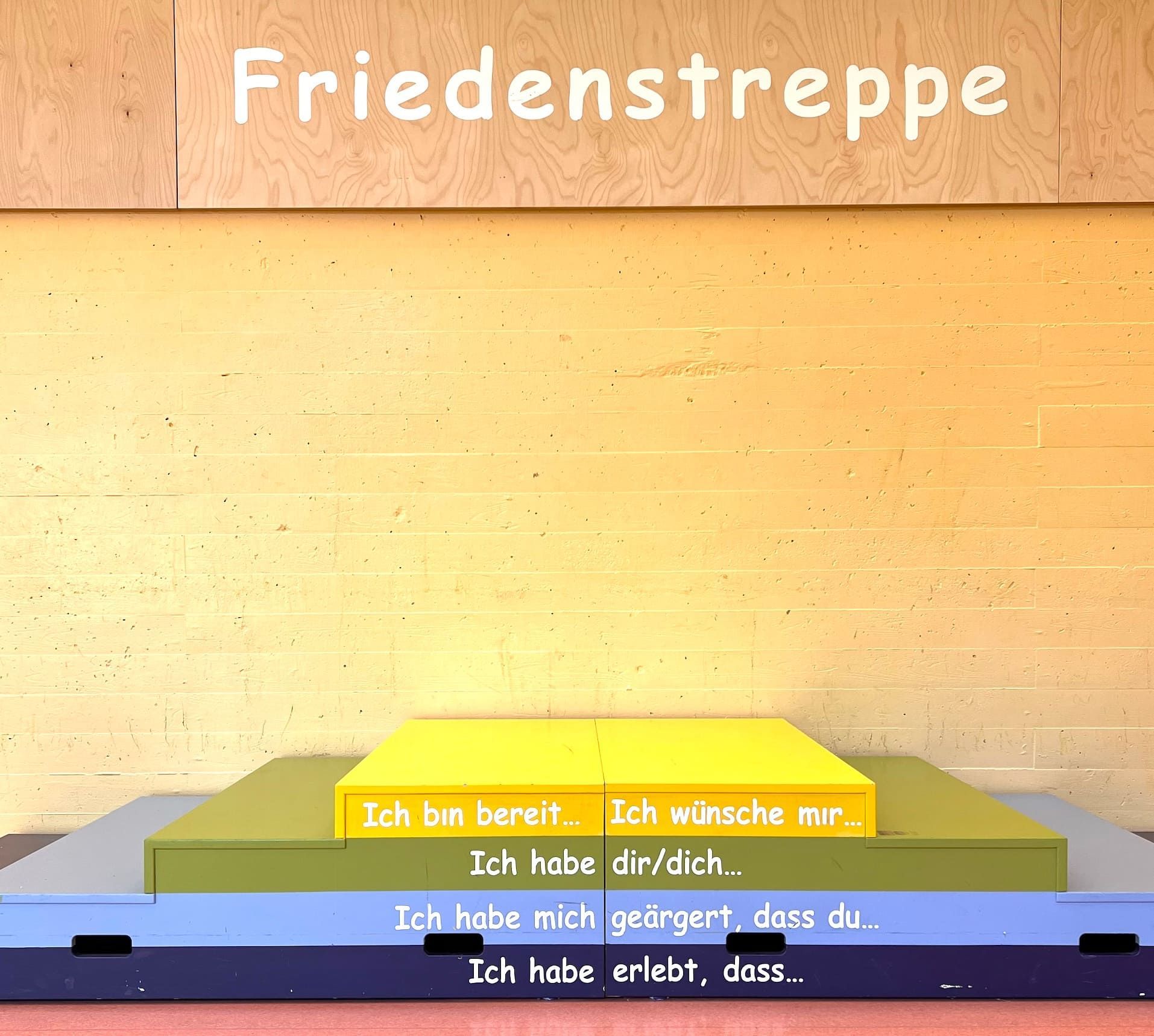 Holzpodest mit 4 Stufen, die die Stufen zum Frieden symbolisieren.