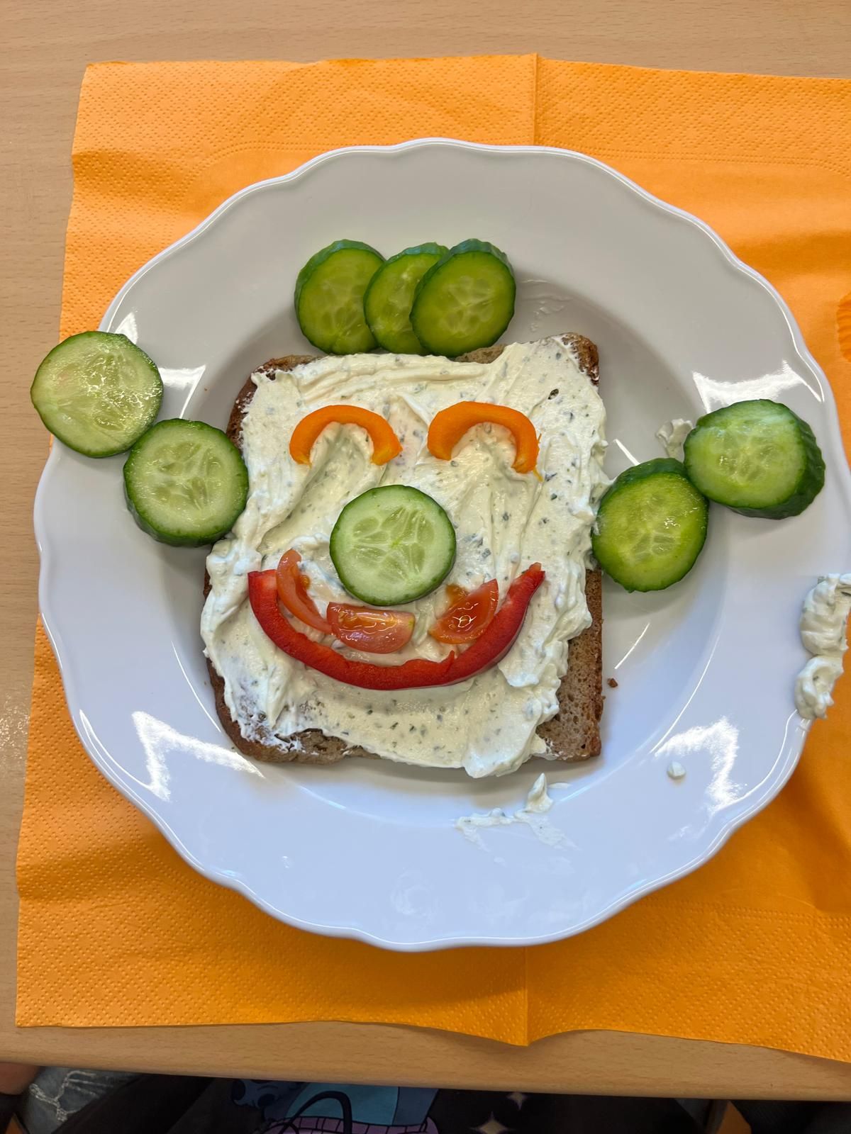belegtes Toastbrot dessen Belag aus Gemüse zu einem Smiley belegt ist