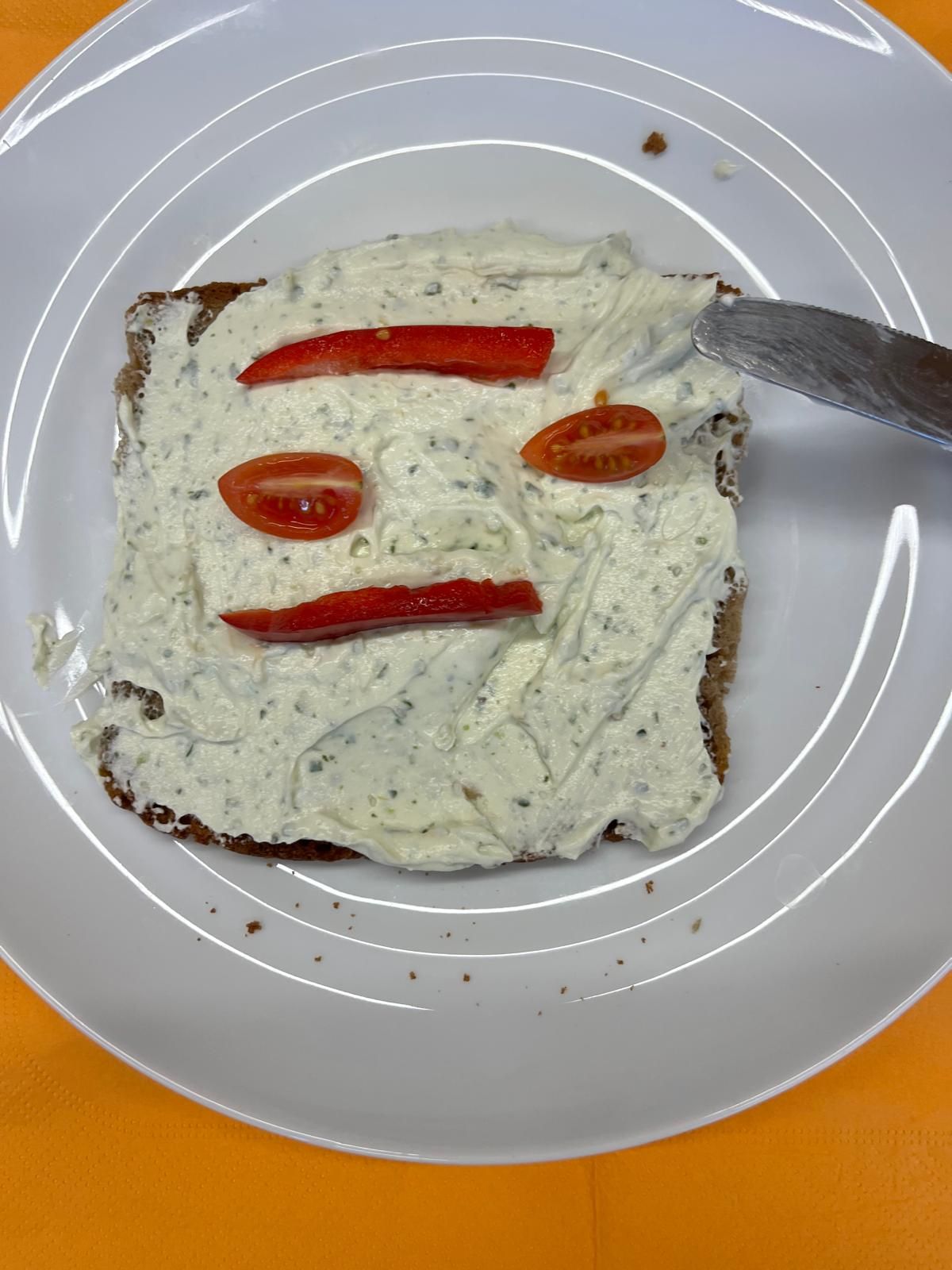 belegtes Toastbrot dessen Belag aus Gemüse zu einem Smiley belegt ist