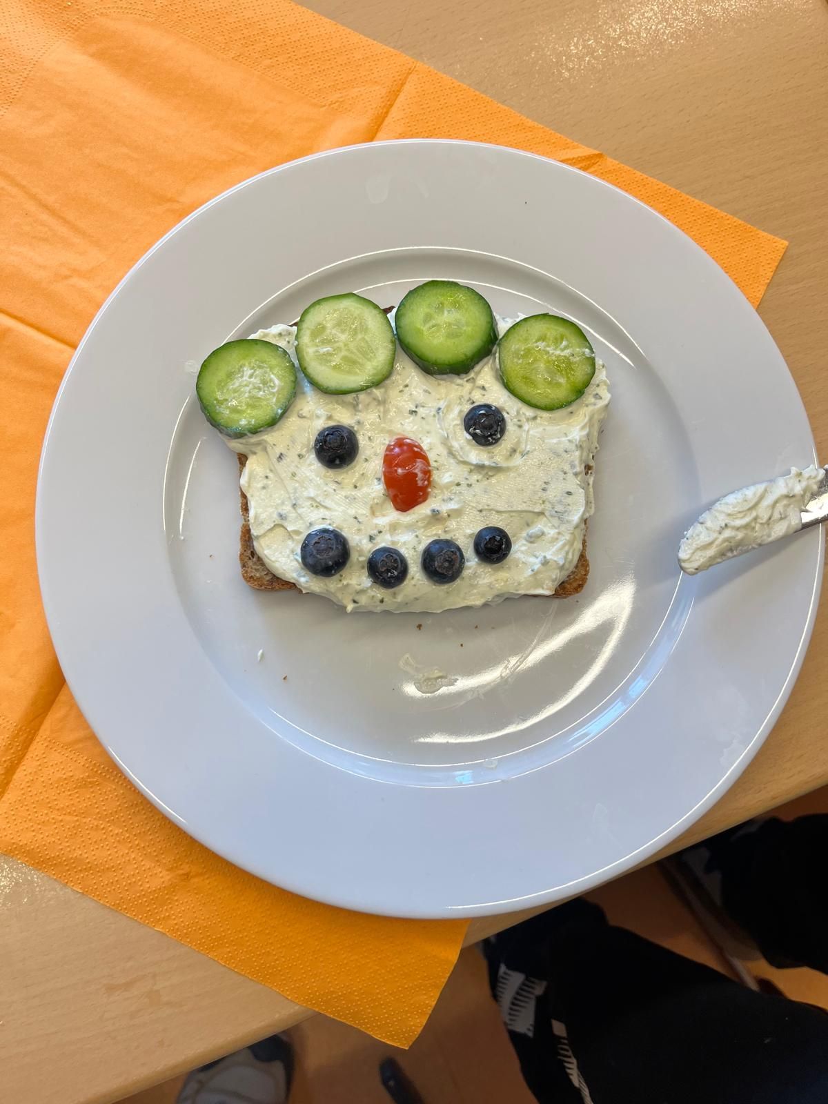 belegtes Toastbrot dessen Belag aus Gemüse zu einem Smiley belegt ist