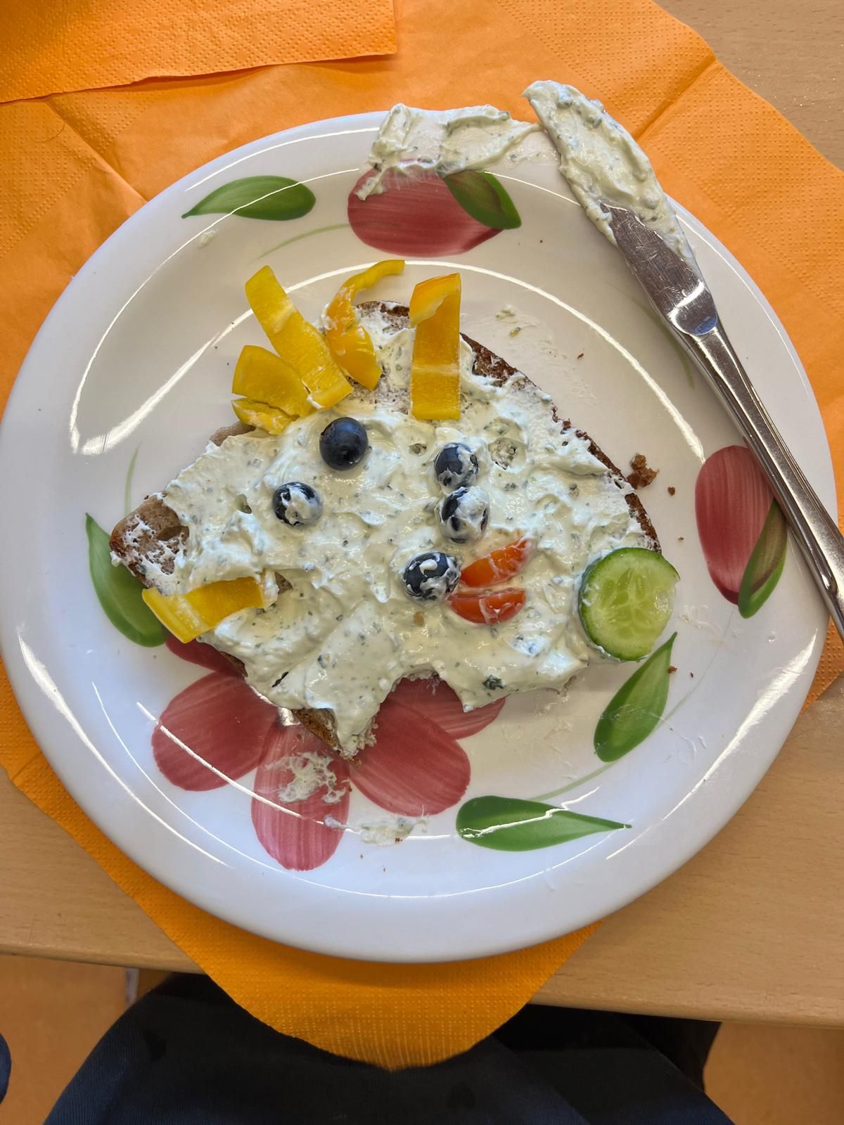 belegtes Toastbrot dessen Belag aus Gemüse zu einem Smiley belegt ist