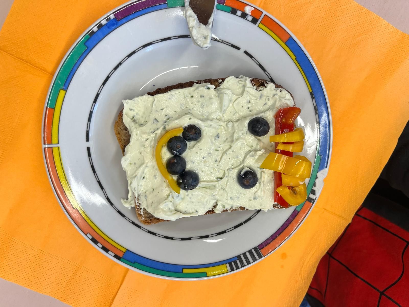 belegtes Toastbrot dessen Belag aus Gemüse zu einem Smiley belegt ist