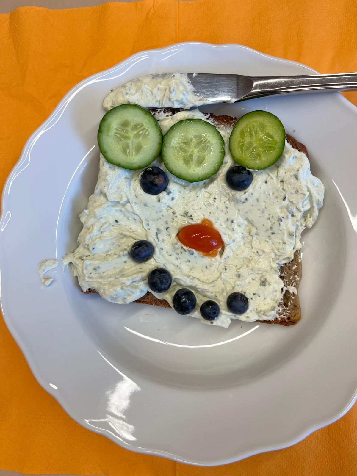 belegtes Toastbrot dessen Belag aus Gemüse zu einem Smiley belegt ist