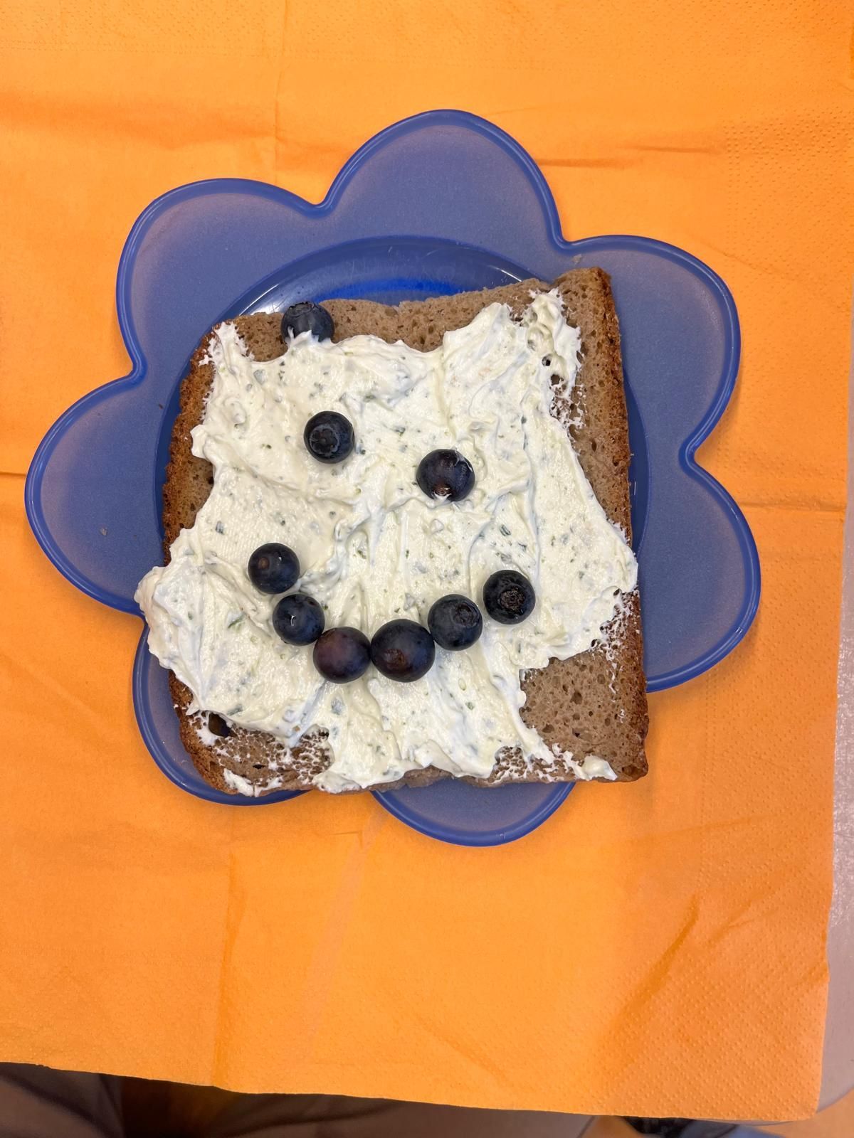 belegtes Toastbrot dessen Belag aus Gemüse zu einem Smiley belegt ist