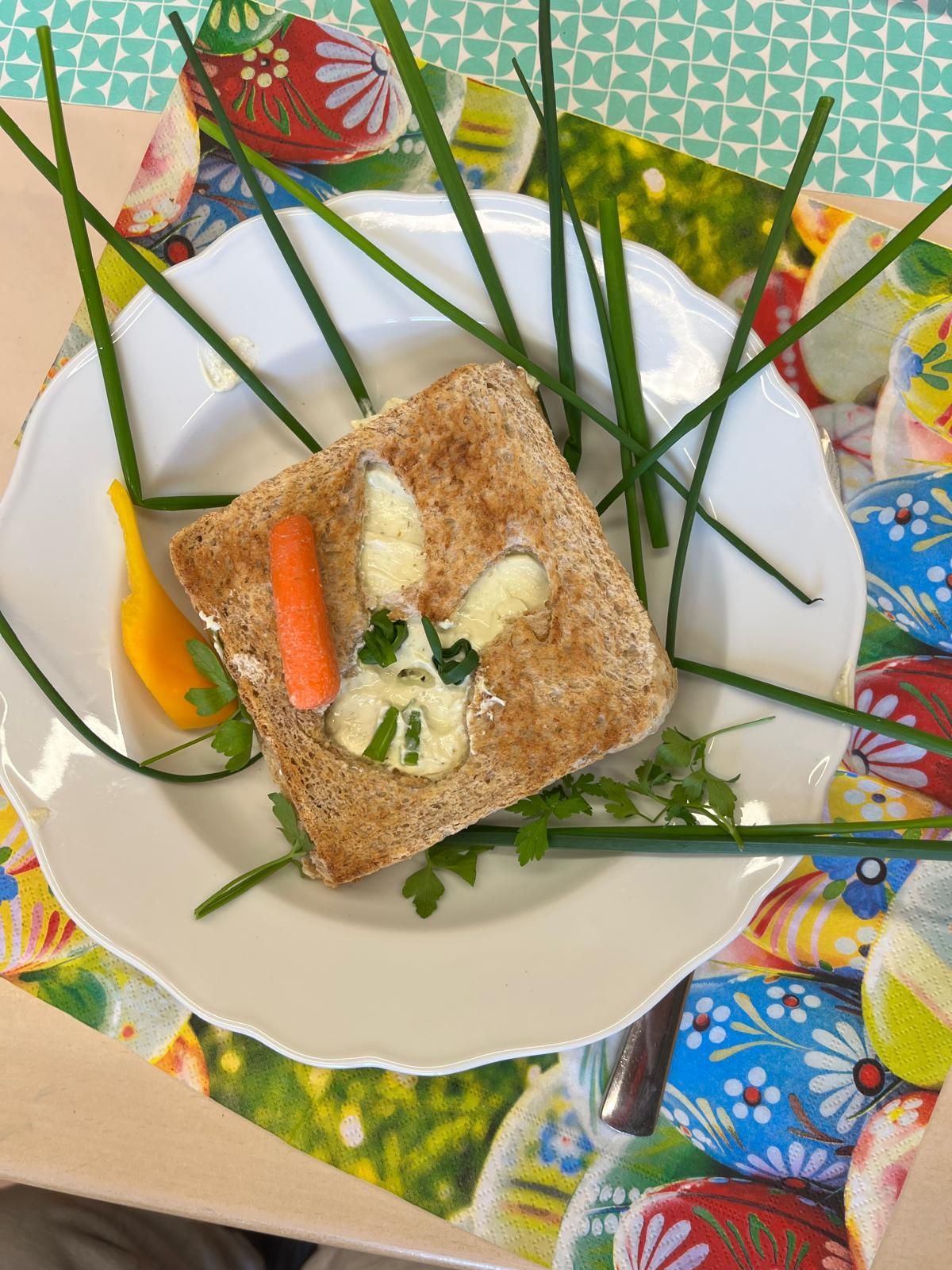 belegtes Toastbrot dessen Belag aus Gemüse zu einem Smiley belegt ist