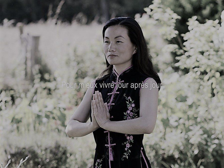femme position de méditation, robe noire et rose avec motif de fleurs