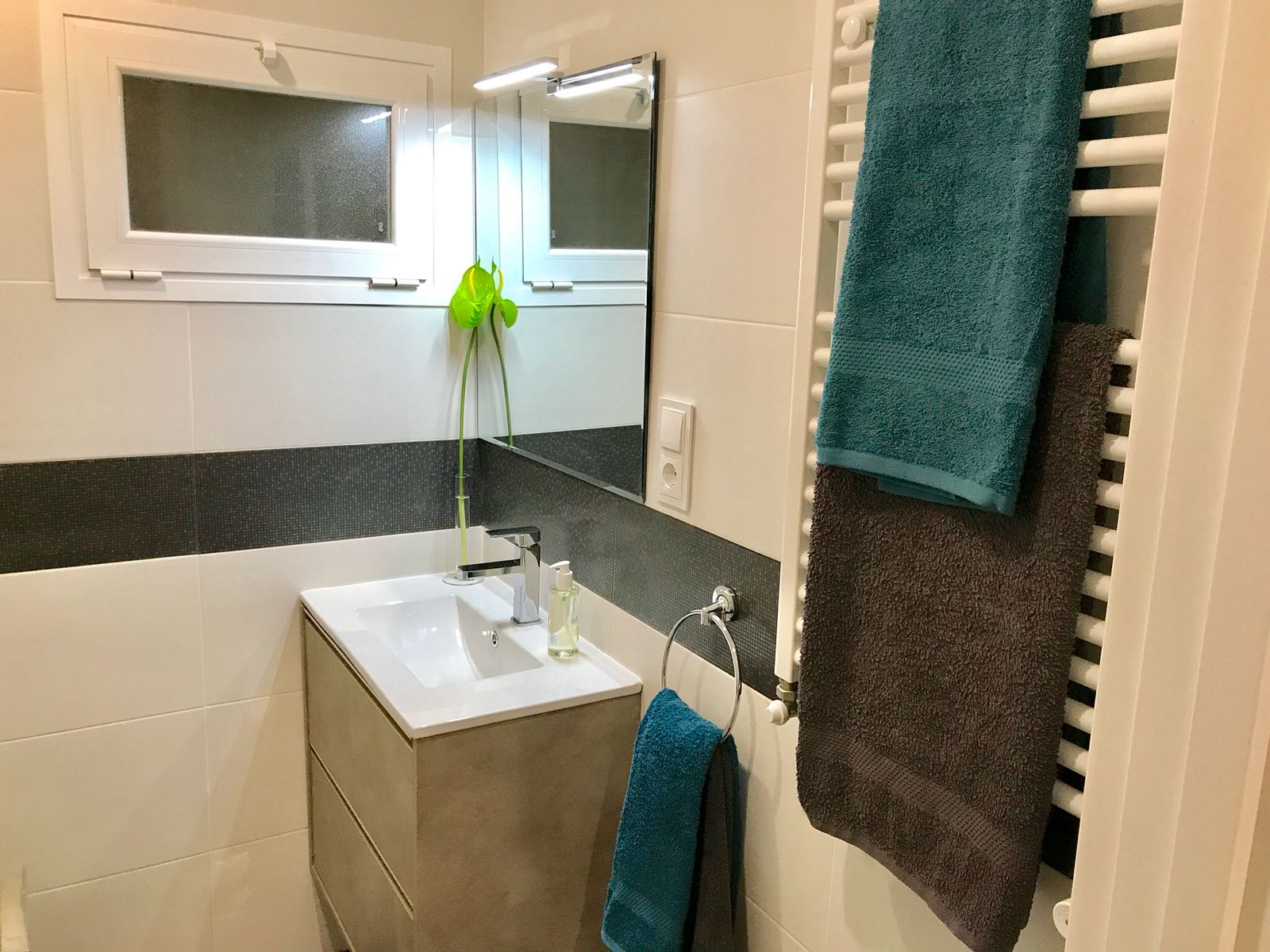 baño reformado detalle calefactor toallas y espejo