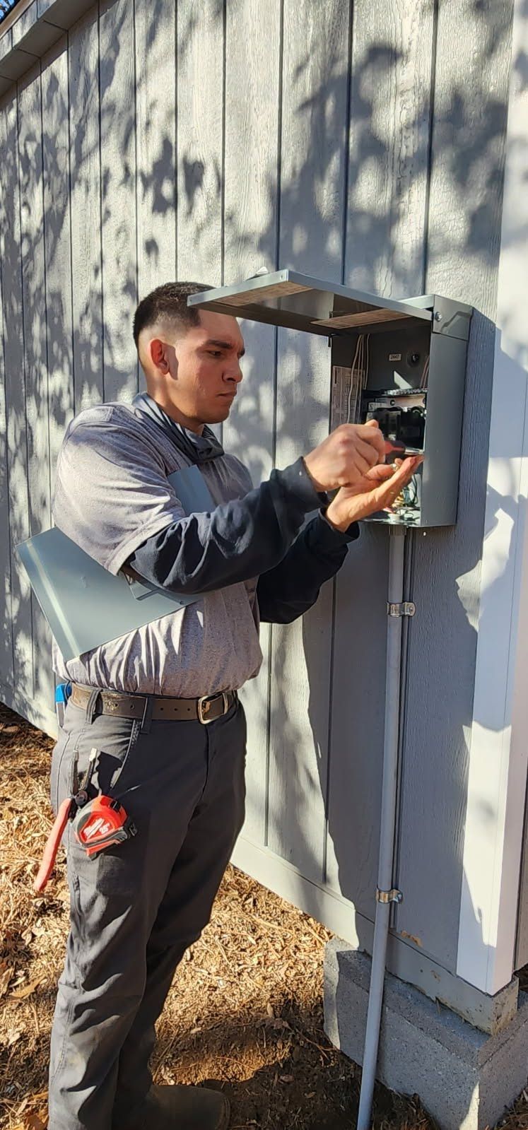 Man connecting electrical wiring outside