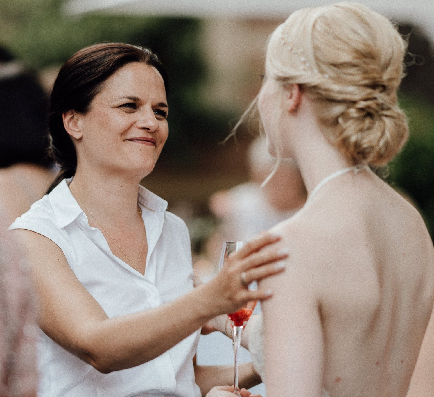 Die freie Traurednerin Kristina Kutz legt im Gespräch voller Achtsamkeit ihre Hand auf die Schulter der Braut.