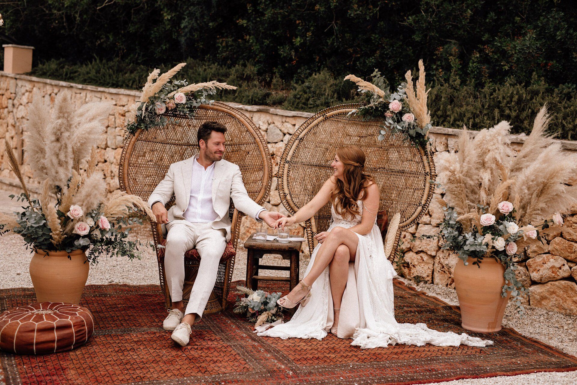 Das Brautpaar sitzt während Freier Trauung mit der Freien Traurednerin Kristina Kutz auf Mallorca auf großen Korbsesseln.