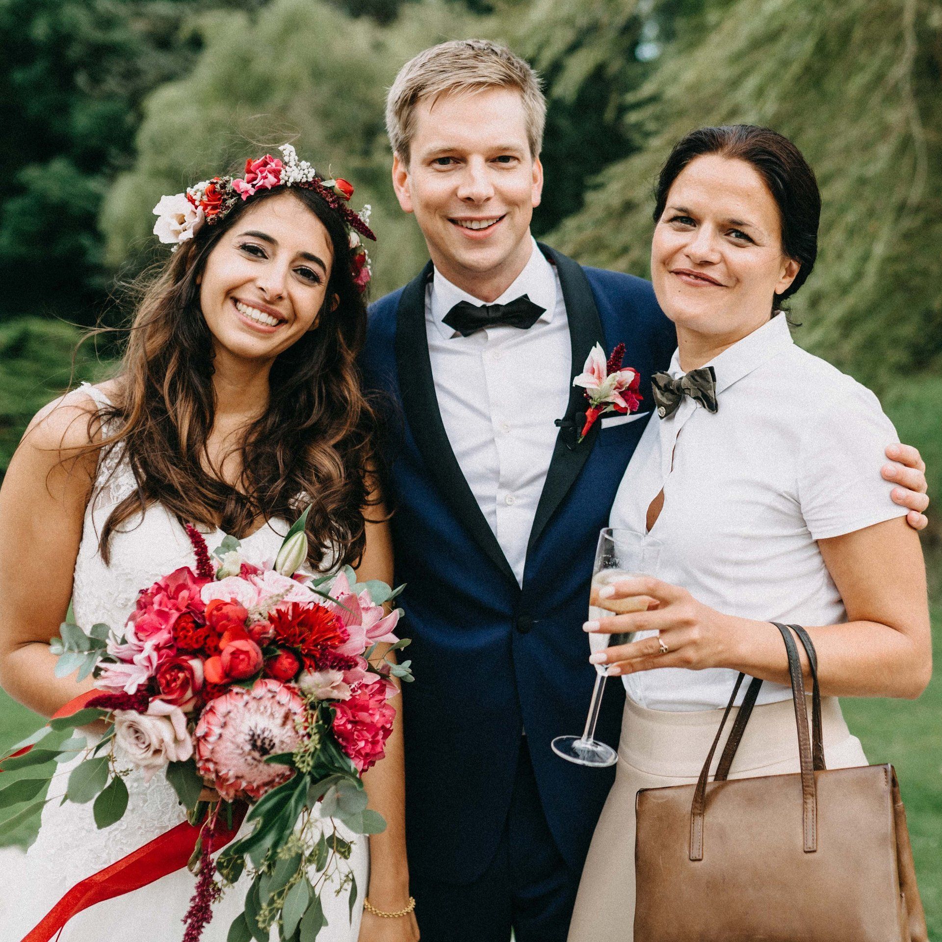 Freie Traurednerin Kristina Kutz  steht nach der Freien Trauung beim Sektempfang an der Seite des Brautpaares, alle strahlen.